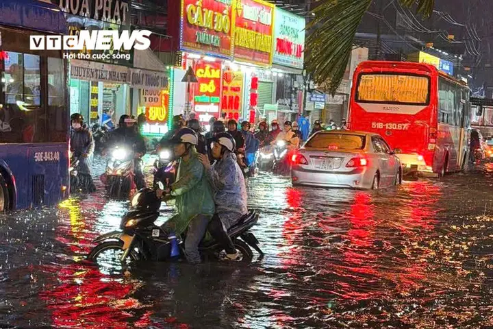 TP.HCM lại mưa ngập, người dân chật vật dắt xe giữa dòng nước
