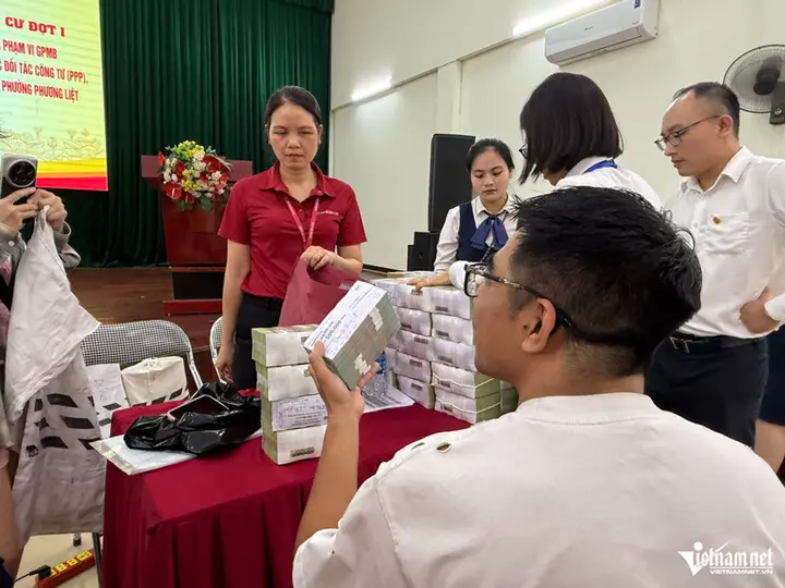 Người dân Hà Nội nhận bao tải tiền bồi thường dự án Quốc lộ 1A